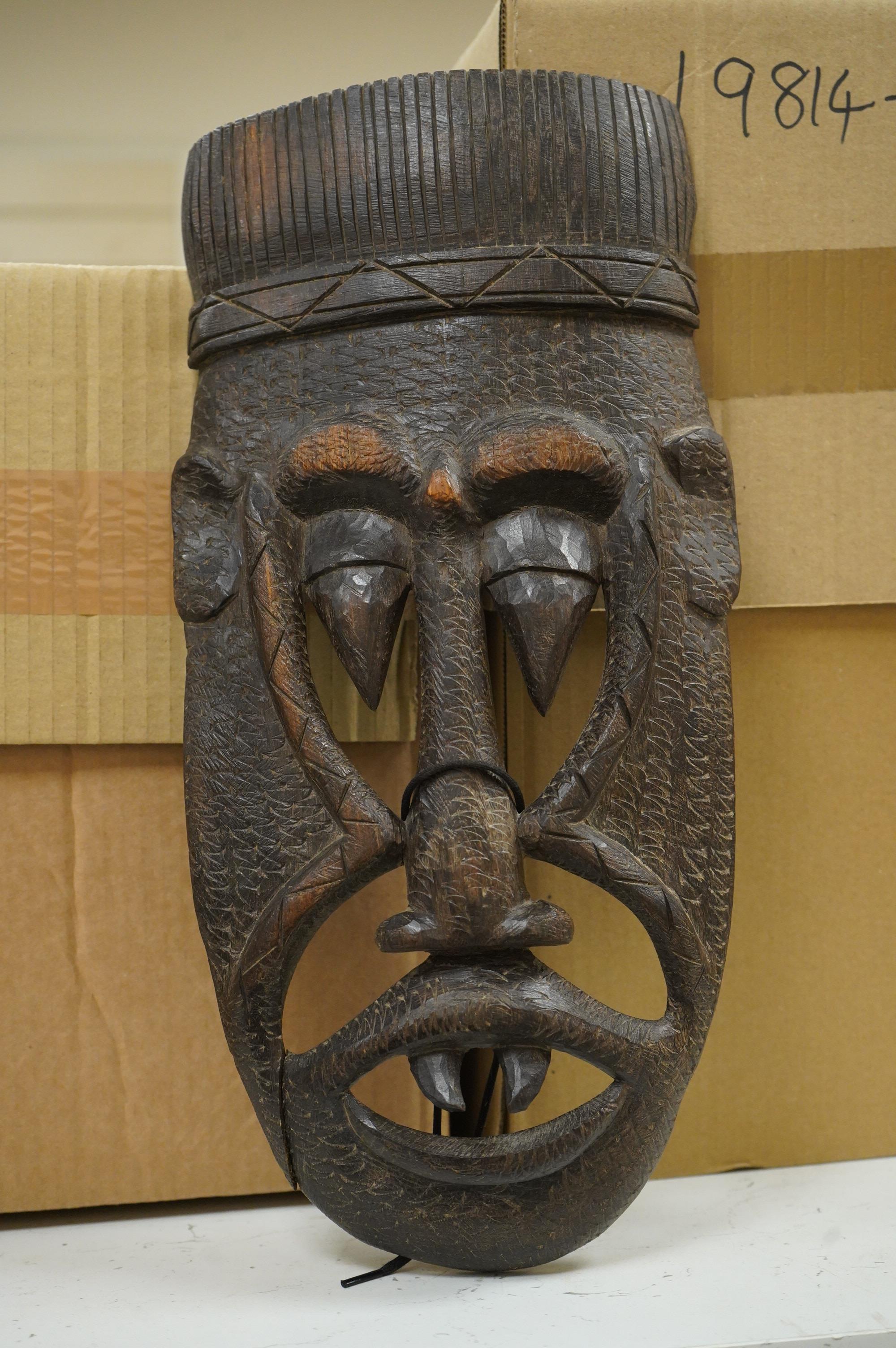 Five ethnographic items; an early 20th century chip carved Australian boomerang-60cm long , together with a later example, a Benin bonds of a warrior seated on a stool, a Makonde African carved figure group and an Africa